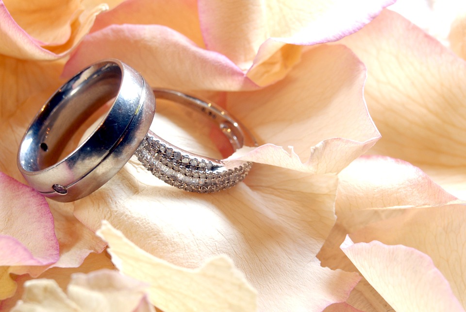 Photo of Engagement Rings in Focus with Couple Out of Focus
